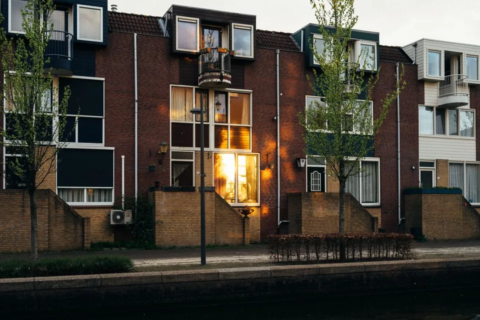 Moderne rijwoningen van baksteen aan het water bij avondlicht